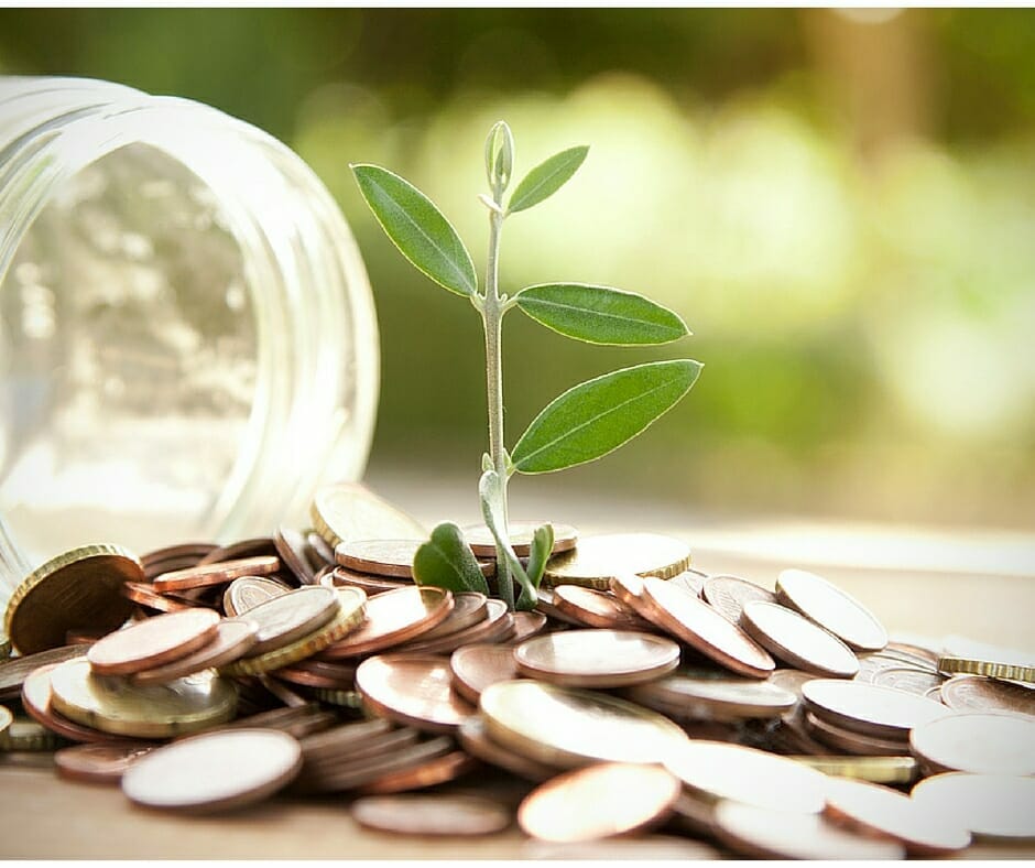 Jar of spilled coins and plant implying living beneath your means