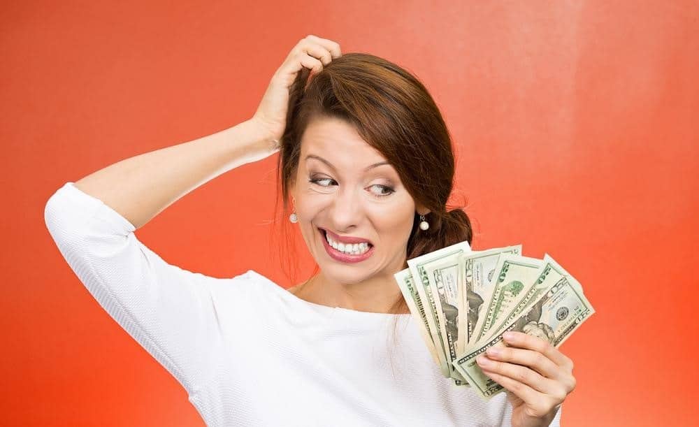Stressed woman holding money